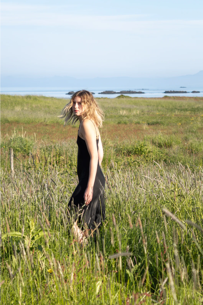 women walking in grass field wearing black dress