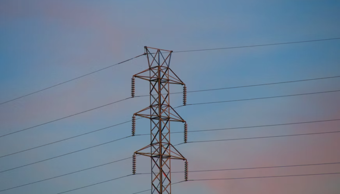 a high voltage power line against a blue sky