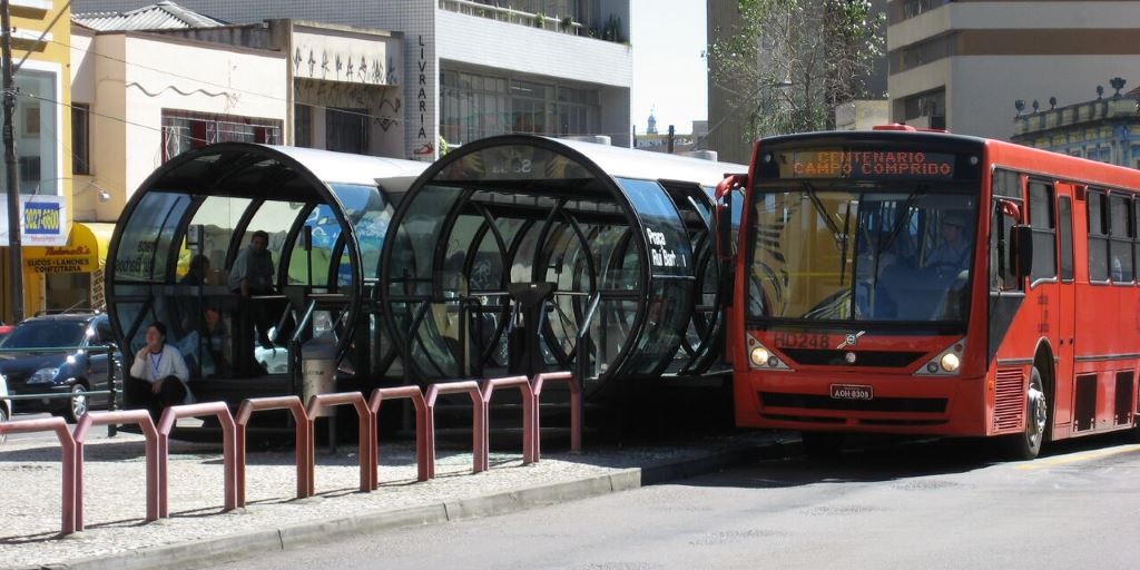 a red bus parked beside waiting tunnel