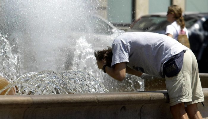 person washing face and hair with water