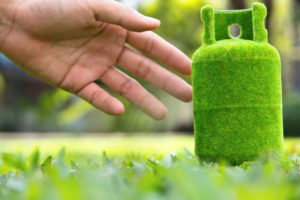 person forwarding hand towards a green cylinder
