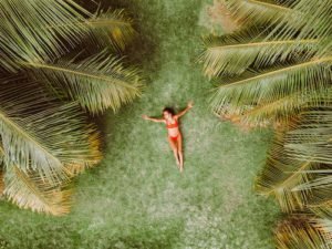 top view of a women lying down in green field wearing red swimwear
