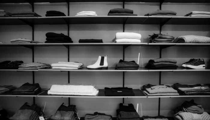 Grayscale Photography of Assorted Apparels on Shelf Rack