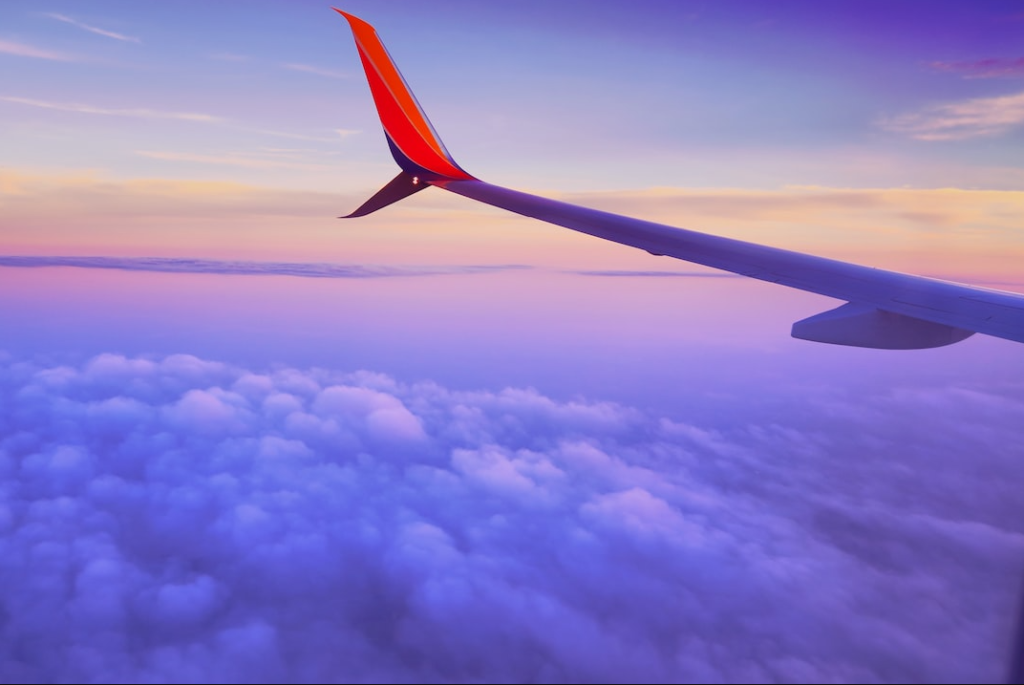 airplane wing while flying above cloud