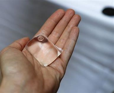 square shaped edible water bottle in persons hand