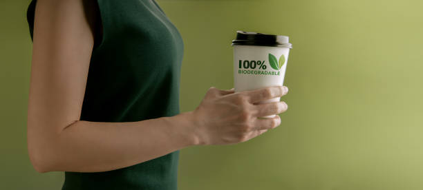 women holding paper cup written biodegradable in it