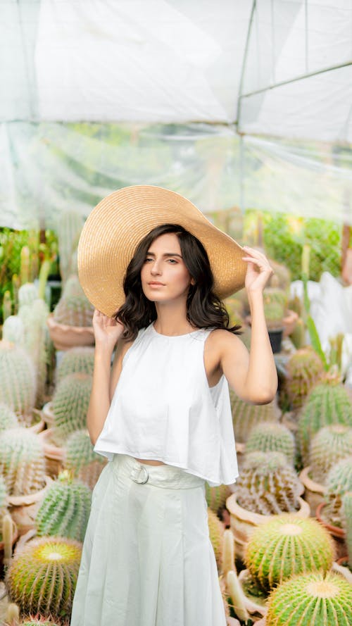 women wearing hat posing for photoshoot in front of cactus plant
