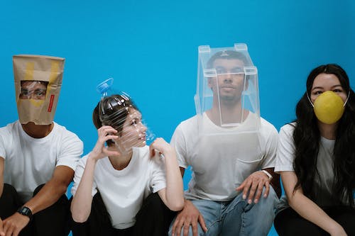 four person sitting wearing plastic and paper packages
