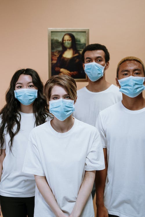 four person standing in white t shirt wearing mask