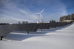 wind turbine and solar panels in a ice covered area