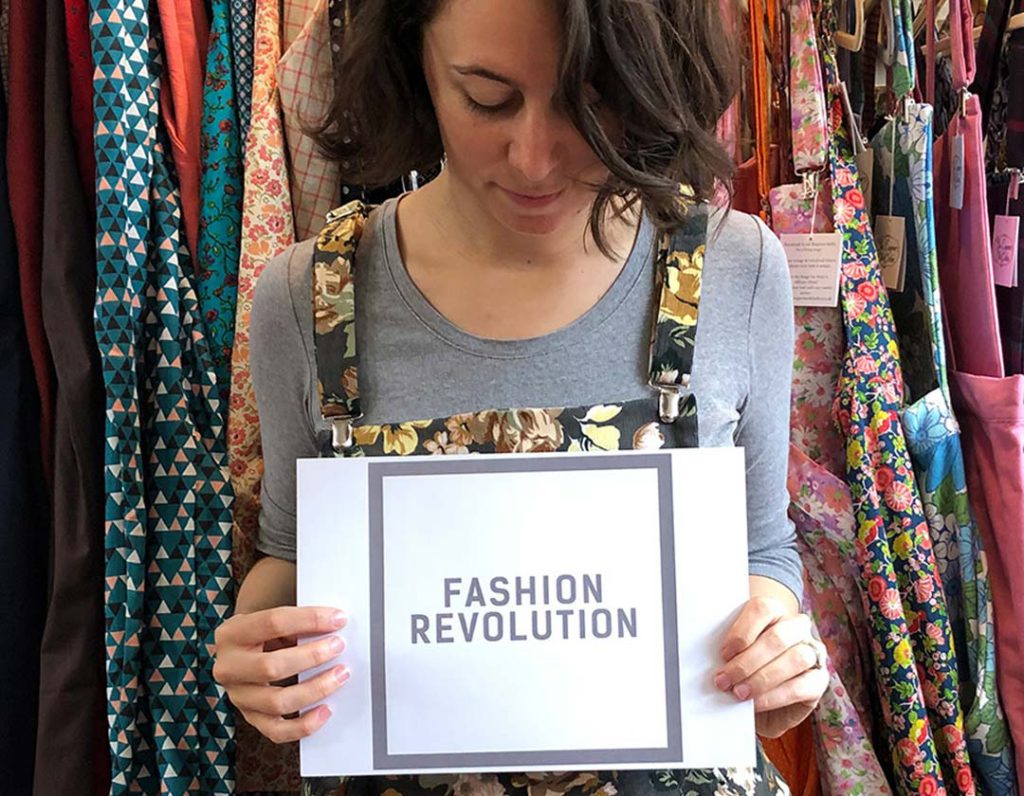 female person holding fashion revolution written paper
