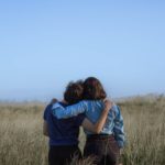 two person standing in a grass field