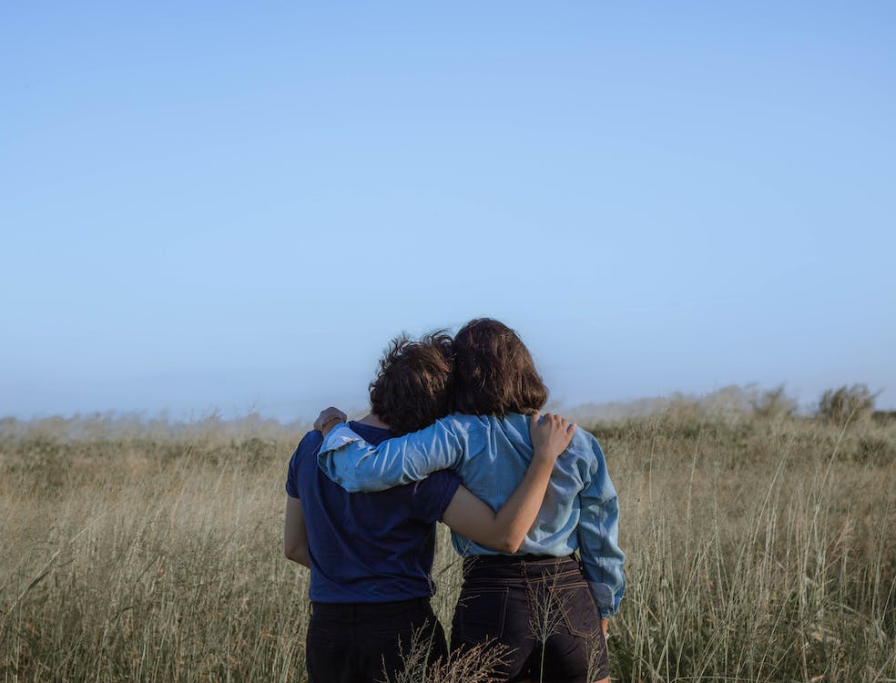 two person standing in a grass field