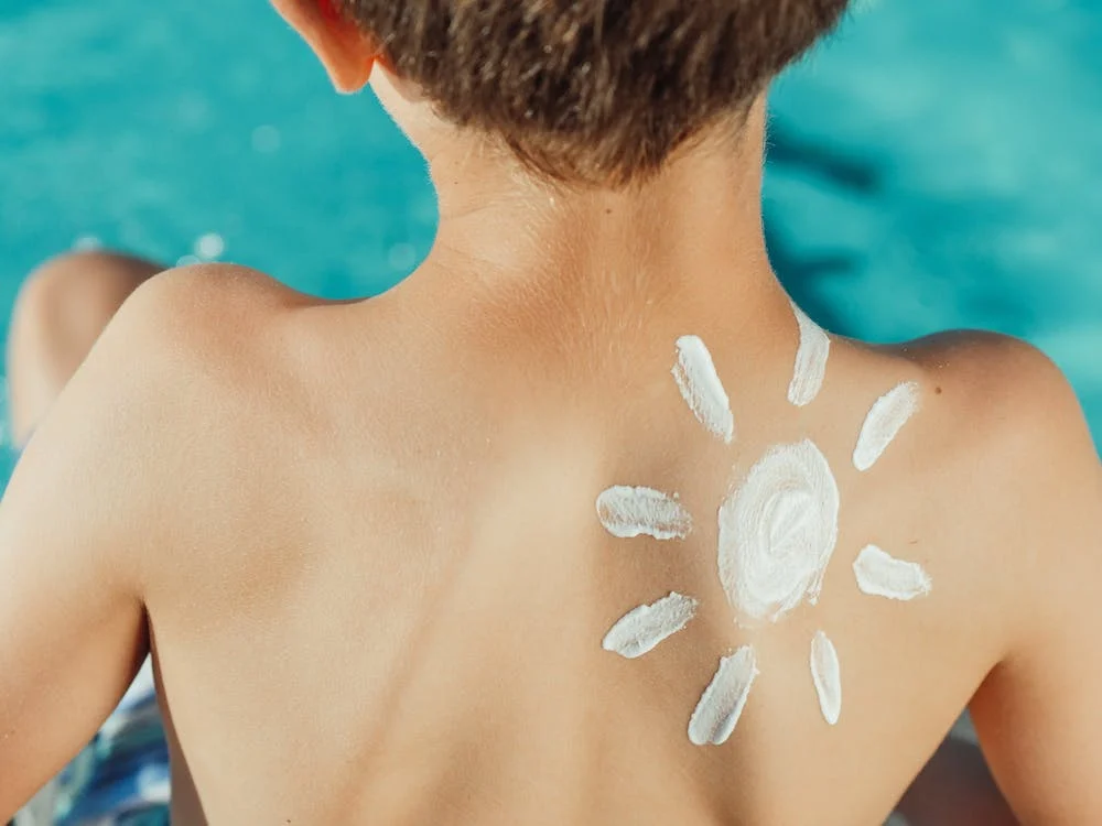sun drawn in the back of a kid with cream