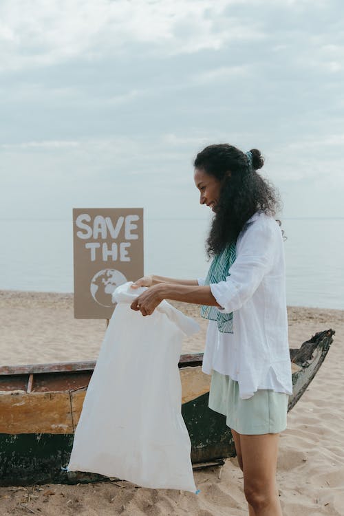 women smiling and collecting beach waste