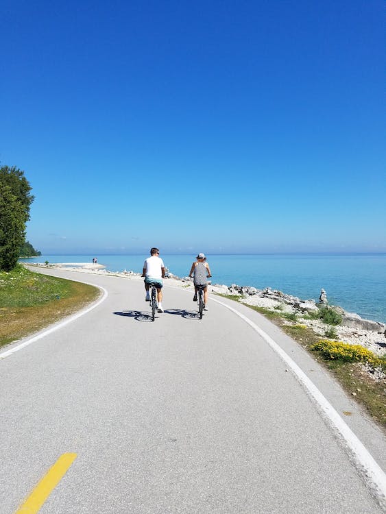 couple riding bicycle in concrete road