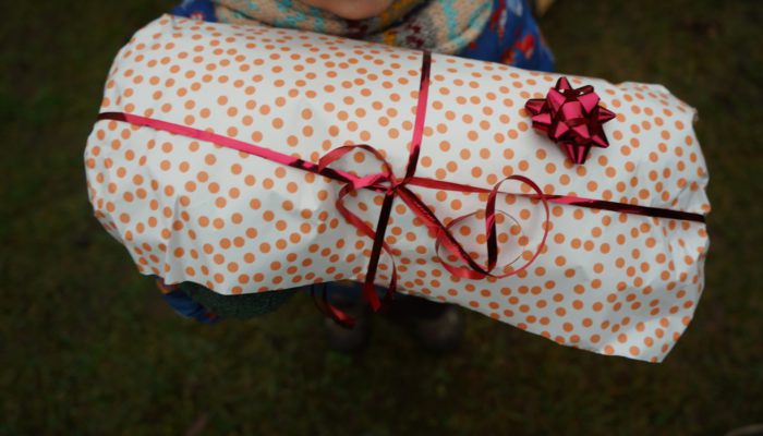 A child holding a wrapped paper present