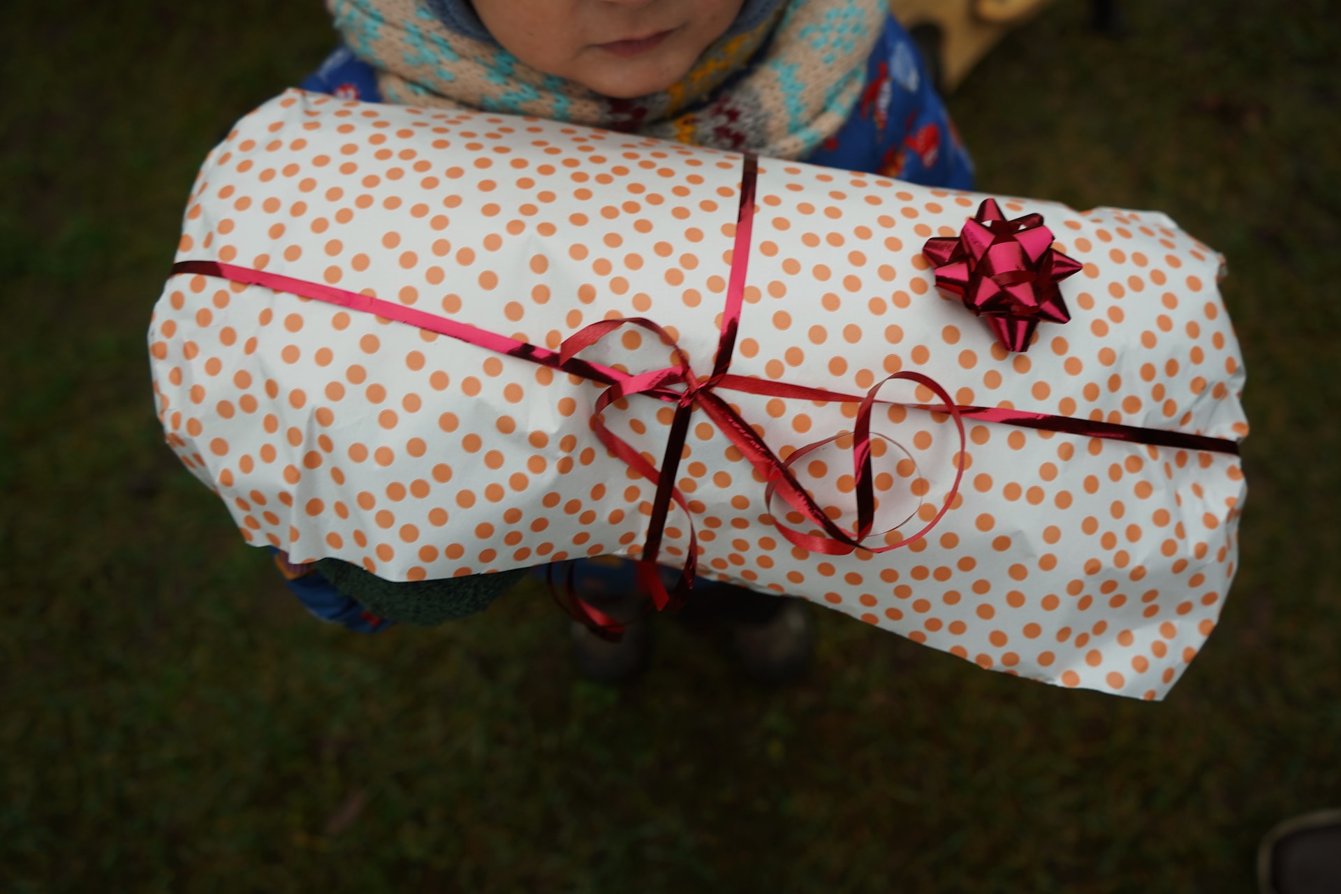 A child holding a wrapped paper present