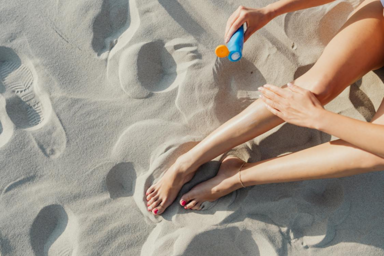 woman applying sunscreen on bare leg