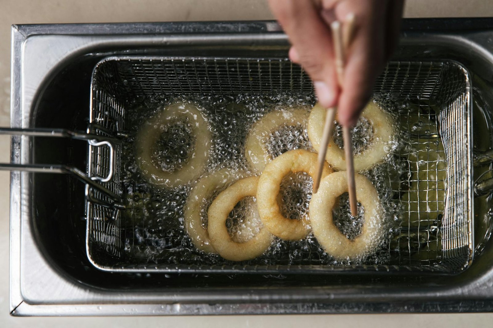 Photo of a Person's Hand Cooking Onion Rings